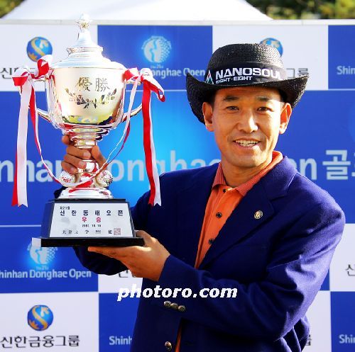 우승트로피를 들고서 활짝 웃고 있는 김종덕